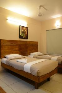 哥印拜陀天籁机场酒店的带三张床和粉笔板的房间