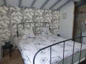 Saint-Pardon-de-ConquesGîtes les Bernes的一间卧室配有一张带黑白色床罩的床。