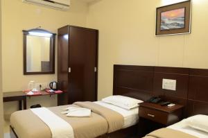哥印拜陀天籁机场酒店的酒店客房,设有两张床和镜子