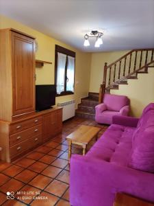 托尔拉卡萨鲁阿塔度假屋的一间带紫色沙发和楼梯的客厅