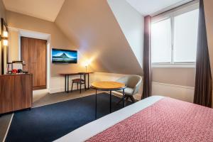 巴黎Holiday Inn Paris - Gare de Lyon Bastille, an IHG Hotel的酒店客房配有一张床铺和一张桌子。