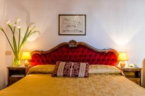 威尼斯爱丽儿希尔瓦酒店的一张带红色床头板的床,上面有枕头