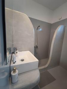阿达玛斯阿格南提酒店的浴室配有白色水槽和淋浴。