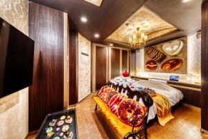 YawataSWEETS HOTEL KYOTO -Adult Only的一间卧室配有一张床和一张长沙发,上面有甜甜圈