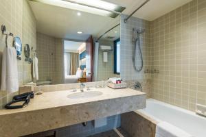 曼谷察殿曼谷沙屯酒店式公寓的一间带水槽、浴缸和镜子的浴室