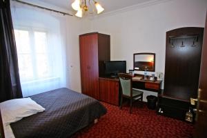 瓦乌布日赫奥斯雷门 - 扎梅克雄日酒店的一间卧室配有一张床和一张带电脑的书桌