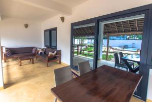平圭Pingwe Beach Apartments的一间带木桌和椅子的用餐室