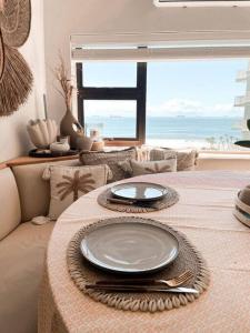 乌姆德洛蒂Umdloti Boho Beach Villa的一张桌子,上面有盘子,享有海景