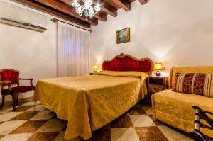 威尼斯爱丽儿希尔瓦酒店的一间卧室配有两张床、一把椅子和一个吊灯。
