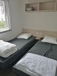 基伯龙Mobile Home For You Quiberon的两张床位于带窗户的房间内