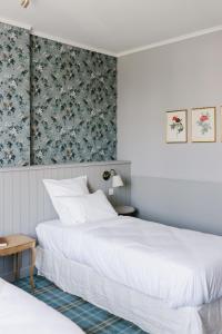 SillyLa Maison d’Hôtes的一间卧室设有两张床和花卉壁纸