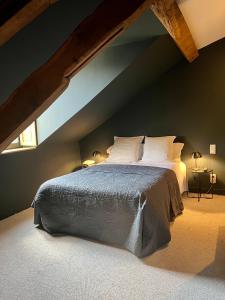 奥比松Hôtel Le France的阁楼上的卧室配有一张大床