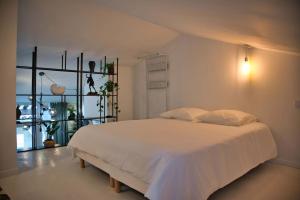 于泽斯Appartement-Terrasse Centre Historique的卧室配有白色的床和窗户。