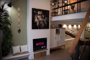 于泽斯Appartement-Terrasse Centre Historique的一间带楼梯的客厅,其中配有电视