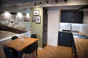 于泽斯Appartement-Terrasse Centre Historique的厨房配有木桌、水槽和台面