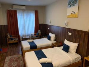 廷布卡木肃穆旅馆的酒店客房设有两张床和窗户。