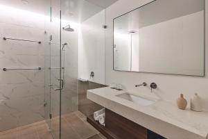 珀斯Rydges Perth Kings Square的一间带水槽和玻璃淋浴的浴室