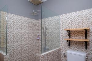日惹Urbanview Hotel Syariah Wisnugraha by RedDoorz的浴室设有玻璃淋浴间和卫生间