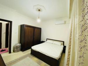 安曼شقه مفروشة الجبيهه的一间带床和木柜的小卧室
