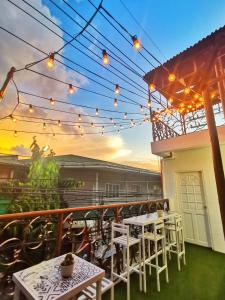 马尼拉NomadsMNL Hostel的庭院配有白色的桌椅和灯光