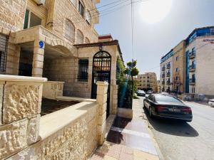 安曼شقه مفروشة الجبيهه的停在街道上建筑物前面的汽车