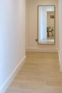 伦敦Gorgeous New 2 Bed Flat - 2 August House的走廊上设有镜子和木地板