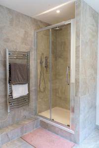 伦敦Gorgeous New 2 Bed Flat - 2 August House的浴室里设有玻璃门淋浴