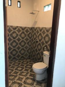 特特巴图Tetebatu Fullmoon的一间带卫生间和瓷砖墙的浴室