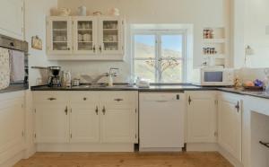 Breathtaking View - 4-BR Home - Scenic Village的厨房配有白色橱柜和窗户。