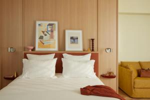 巴黎OKKO Hotels Paris Rosa Parks的一间卧室配有一张带白色枕头和黄色椅子的床