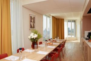 巴黎OKKO Hotels Paris Rosa Parks的长长的用餐室配有长桌子和椅子
