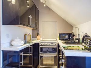 DinmoreThe Studio的厨房配有不锈钢用具和黑色橱柜