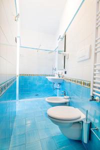 马奥莱潘多拉别墅酒店的蓝色的浴室设有2个卫生间和水槽
