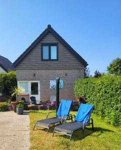 奥德多普Vakantiehuis 't Hertenkamp的两把蓝色椅子在房子前面