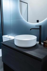 巴埃萨Nido Baeza Suites的浴室设有黑色柜台上的白色水槽