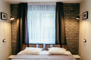 卢扎Villa Fortuna的一间卧室配有床和带窗帘的窗户