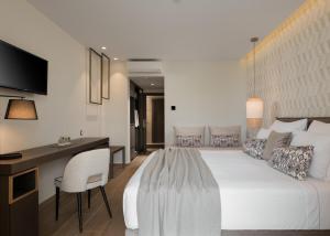 罗希姆诺塞亚泰米斯宫殿酒店的卧室配有一张白色大床和一张书桌