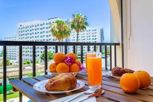 多列毛利诺斯Imperial Puerto 2 3F By IVI Real Estate的一张桌子,上面放着橙子、羊角面包和一杯橙汁