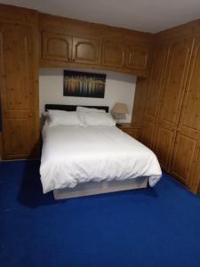 Streatham ValeSandra的一间卧室配有一张白色大床和木柜