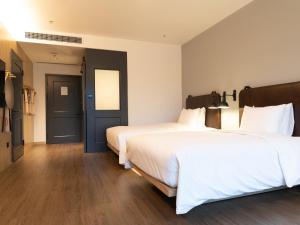 深圳深圳北站Moxy酒店的酒店客房带两张床和一扇蓝色门