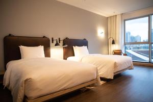 深圳深圳北站Moxy酒店的酒店客房设有两张床和窗户。