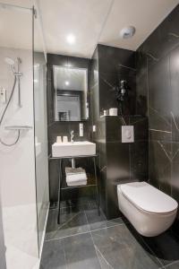阿让Cit'Hotel Stim'Otel的浴室配有卫生间、盥洗盆和淋浴。