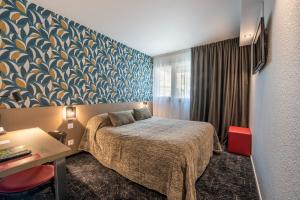 阿让Cit'Hotel Stim'Otel的配有一张床、一张书桌和一扇窗户的酒店客房
