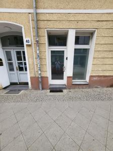 柏林Apartment Pette C40的建筑物的两扇门,有一个人站在外面