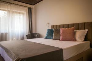 普雷代亚尔Vila Smaranda的一间卧室配有一张大床和枕头