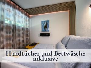 绍纳赫Relax-Apartment 164 mit Indoor-Pool, Sauna, Küche und Netflix的一间卧室配有一张床,窗户配有文字家具和冰箱。