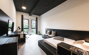 诺伊斯MoLiving - Design Hotel & Apartments Düsseldorf-Neuss的一间卧室配有一张床和一张沙发