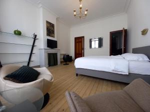 奥斯坦德Villa Stella Maris的一间卧室配有一张床、一张沙发和一把椅子