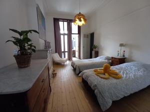 奥斯坦德Villa Stella Maris的卧室配有两张床,地板上配有一个黄色的水壶。