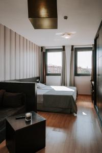 萨拉曼卡Zenit Hall 88 Studios的酒店客房,配有床和沙发